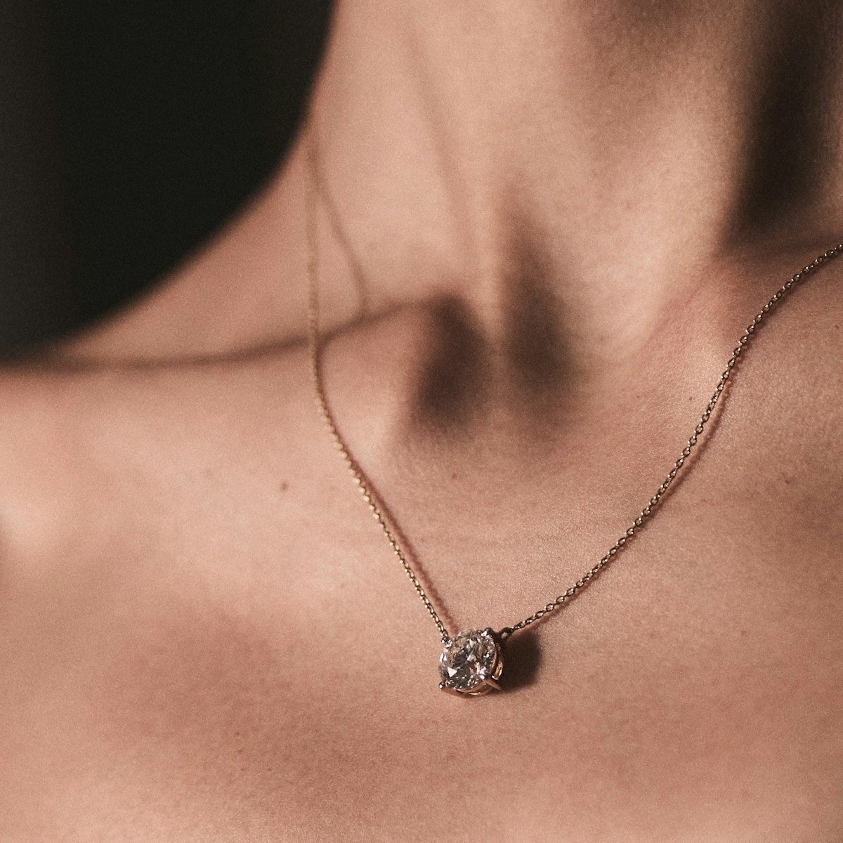 woman wearing diamond pendant