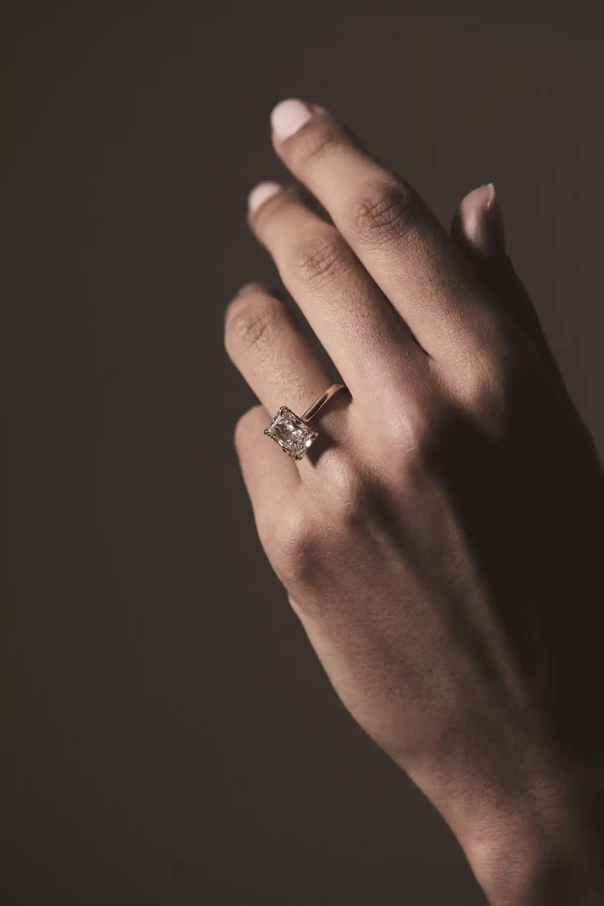 emerald cut diamond engagement ring in hand