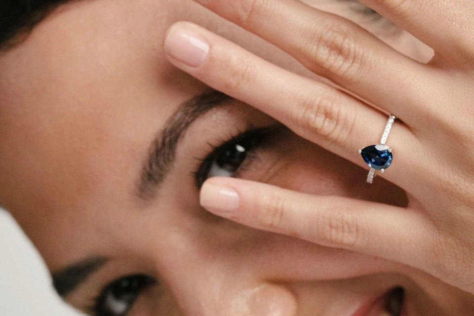 woman wearing pear cut sapphire engagement ring