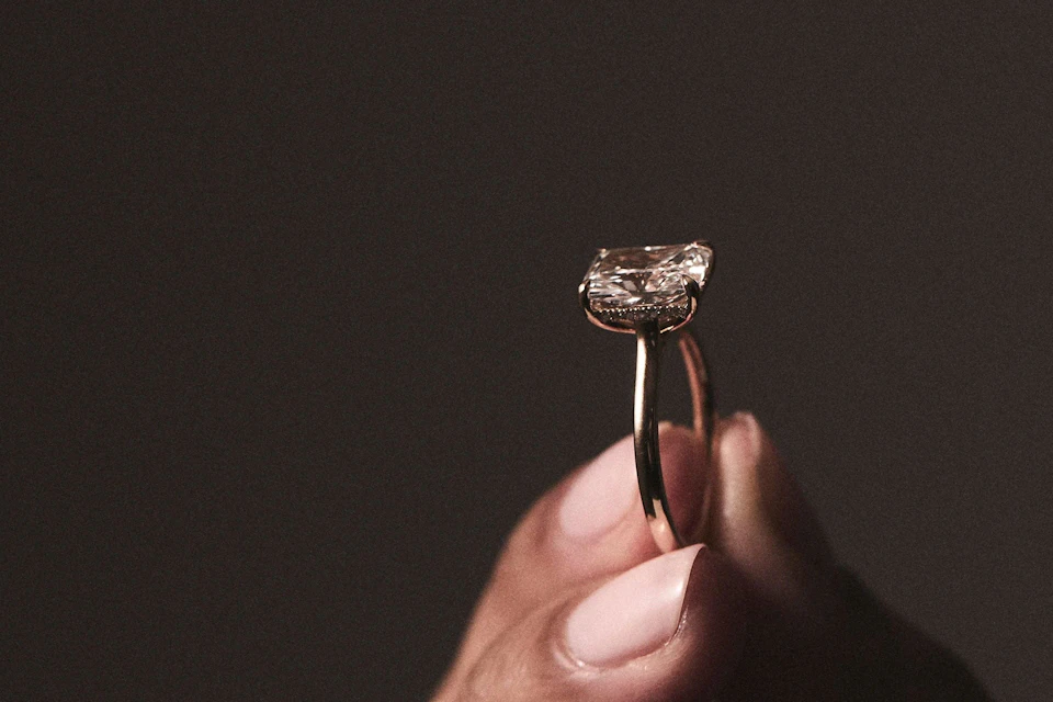 hand holding a diamond engagement ring
