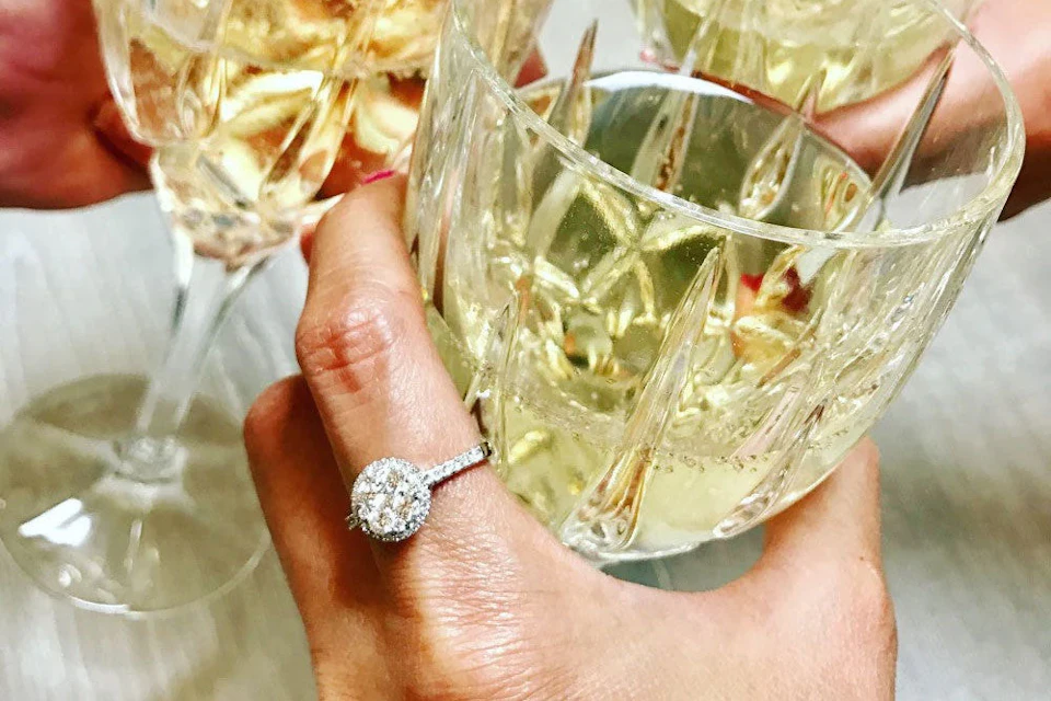 champagne toast wearing a diamond engagement ring