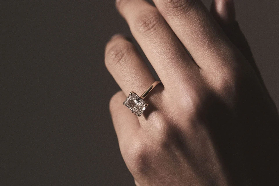 emerald cut diamond engagement ring in hand