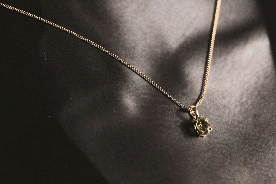 peridot gold pendant necklace over model black and white photograph