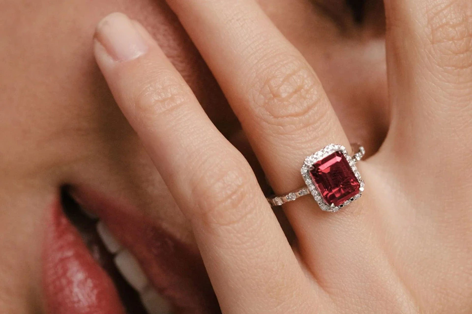 ruby gemstone with diamond halo and sidestones engagement ring